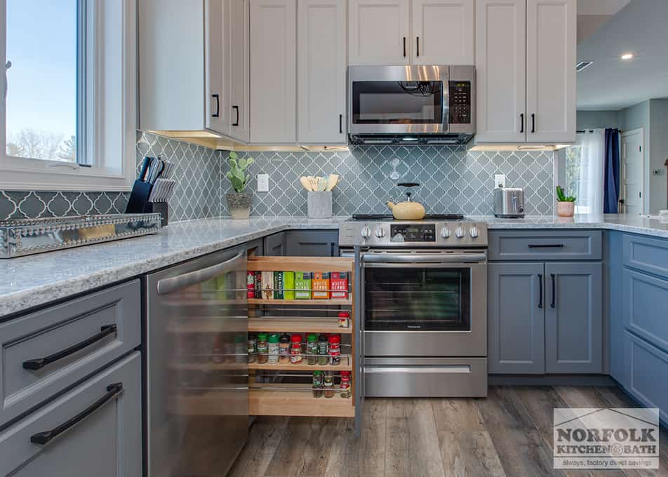 a kitchen remodel in Hampton Falls, NH featuring white and grey kitchen cabinets with a pull out spice drawer