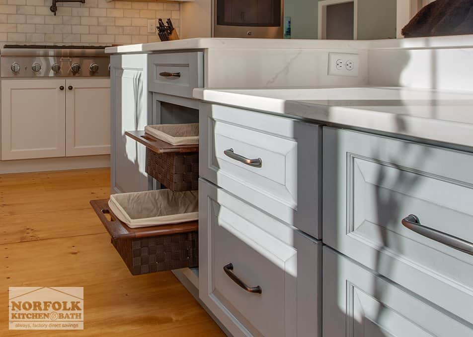 close up of a grey kitchen island with pull out baskets instead of drawers