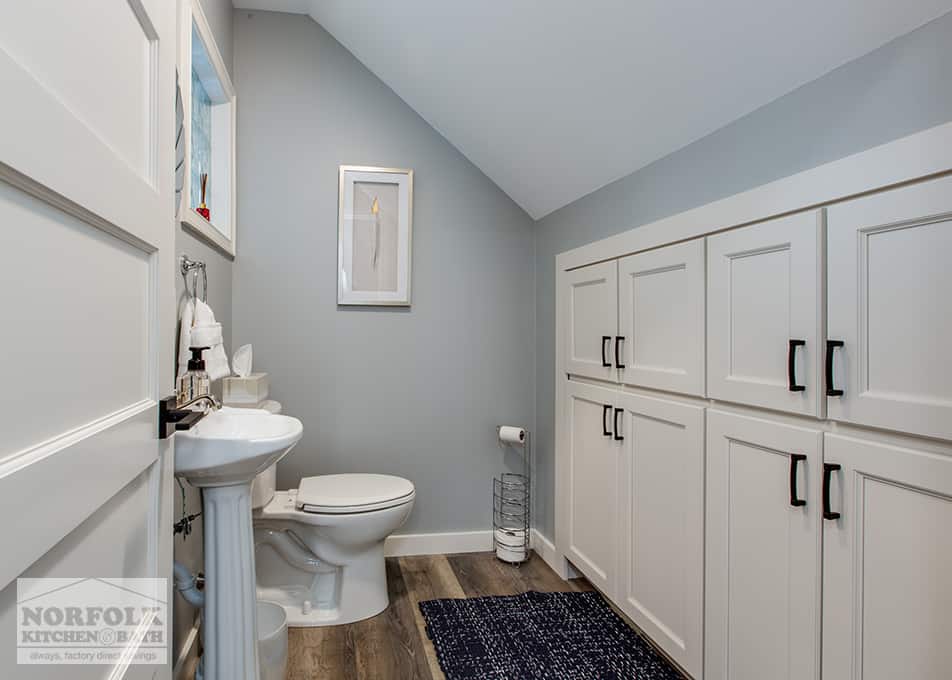 a small bathroom with white cabinet built ins