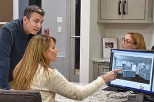 Couple at designer desk pointing at computer design