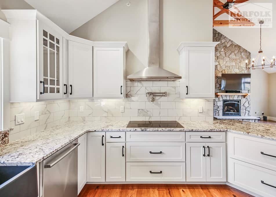 white kitchen cabinets with an electric stove insert and a stainless steel range hood