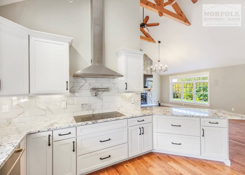white kitchen with an electric stove insert and a stainless steel range hood