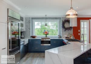 contemporary gloss blue cabinets with quartz waterfall island and orange paint