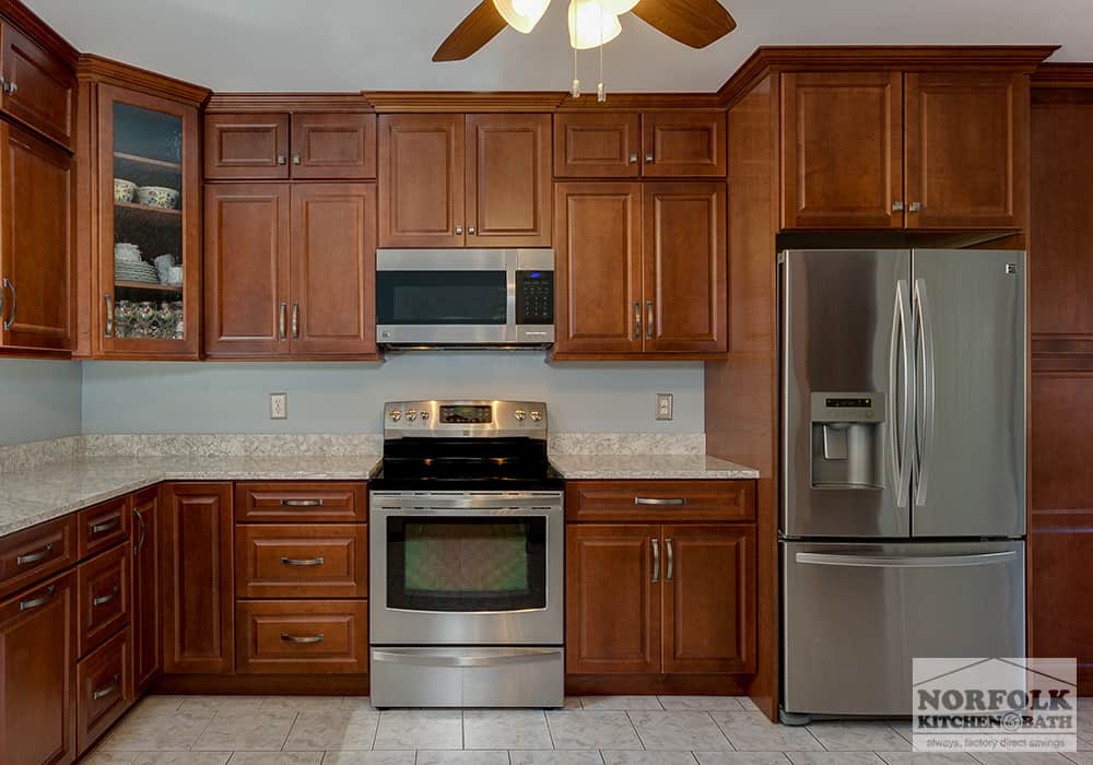 medium tone wood cabinets in kitchen with stainless appliances