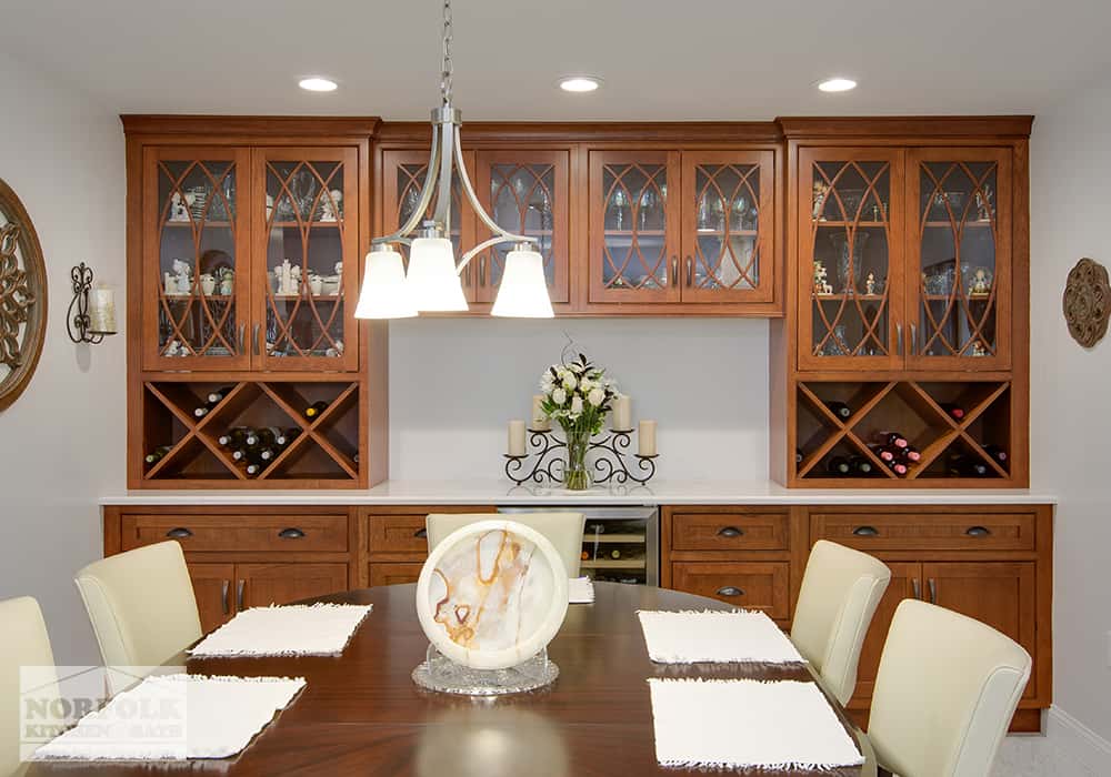 dining table with custom cabinets and wine racks completing a wet bar