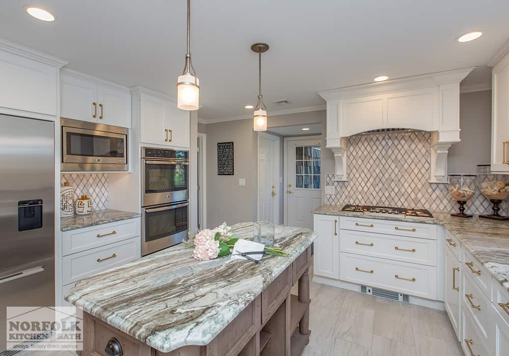 gorgeous white kitchen with xtra large painted wood hood and green color in the granite island
