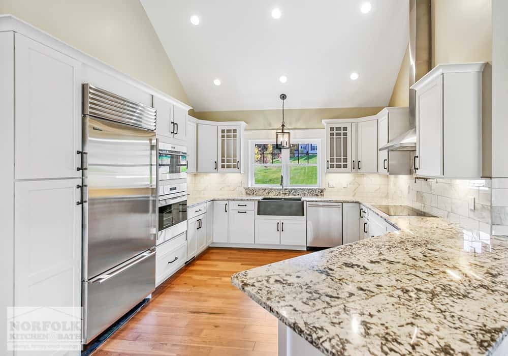 white kitchen with granite countertops and stainless steel appliances in Gilford, NH