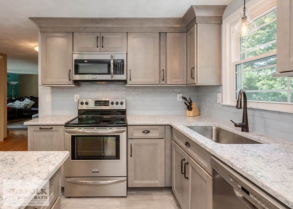 a Wilmington kitchen remodel with shaker cabinets in a gray stain, white stone countertops and stainless steel appliances