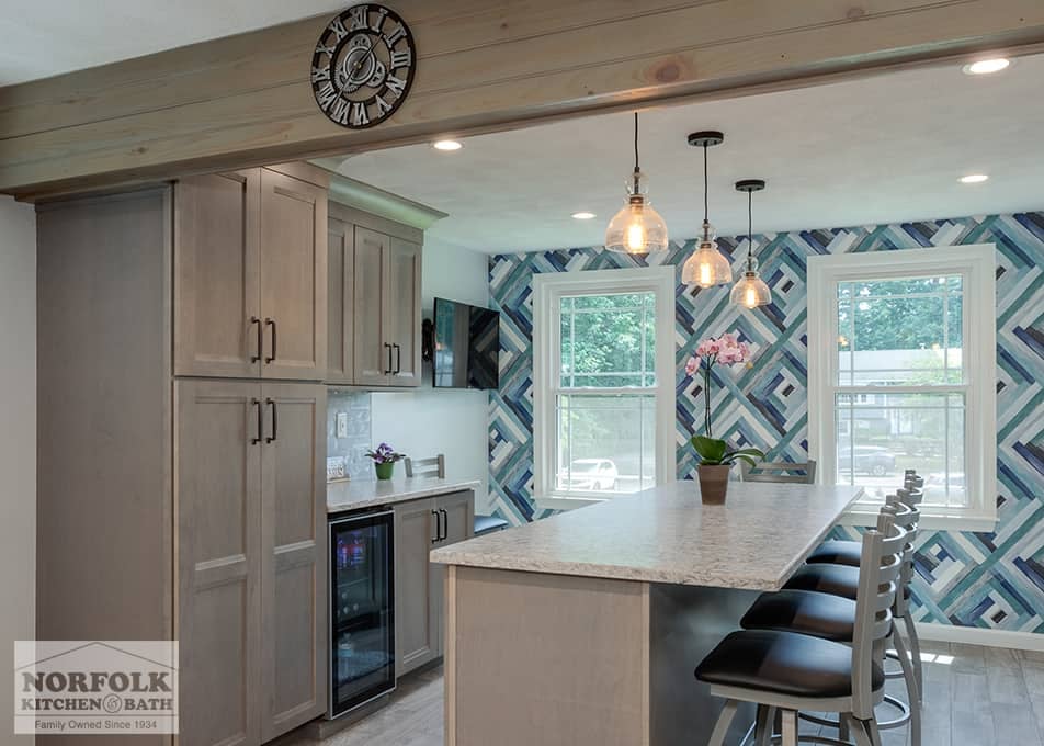 a Wilmington kitchen remodel featuring shaker cabinets in a gray stain, white stone countertops and a large island with seating