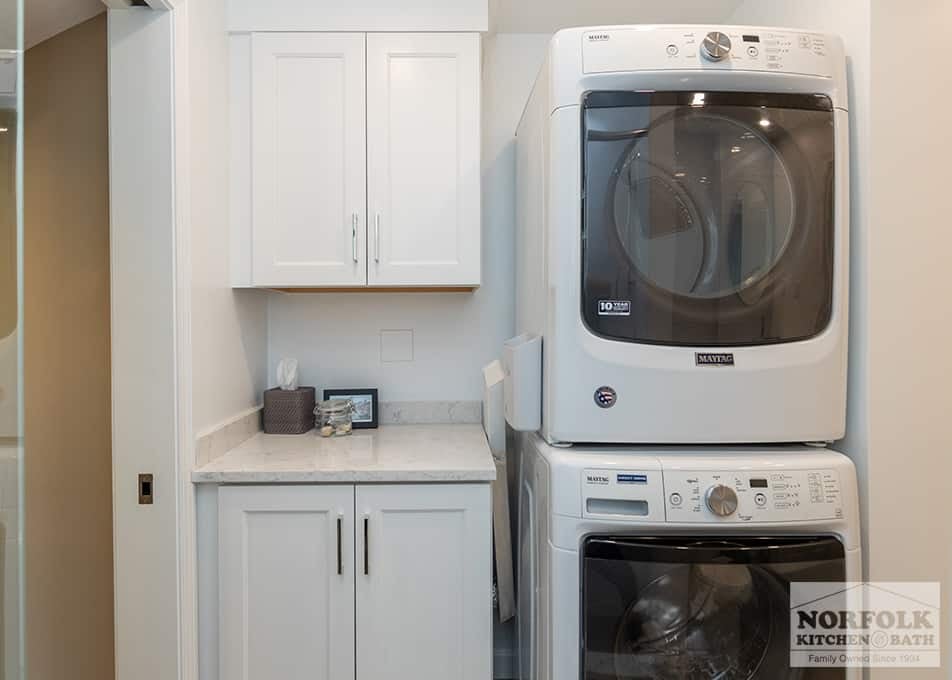 laundry room remodel in Quincy, MA with white shaker cabinets and a stacked washer and dryer