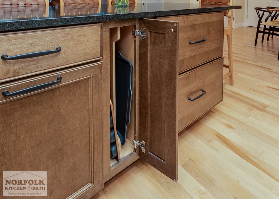 stained wood kitchen island with a special cabinet to hold cutting boards and baking trays