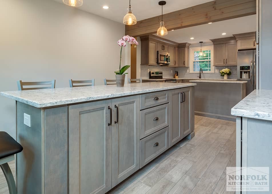 a large kitchen island in Wilmington with shaker cabinets in a gray stain and white stone countertops