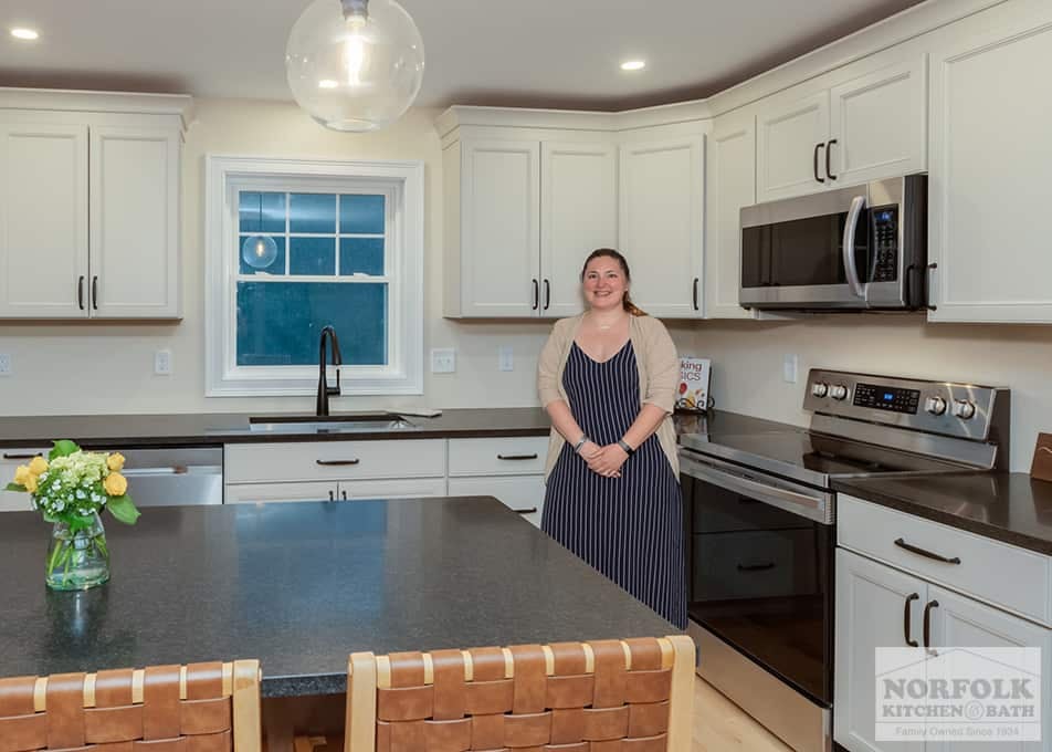 Kimberly, a Norfolk Kitchen & Bath designer, standing in one of her finished kitchen remodels in Hudson, NH