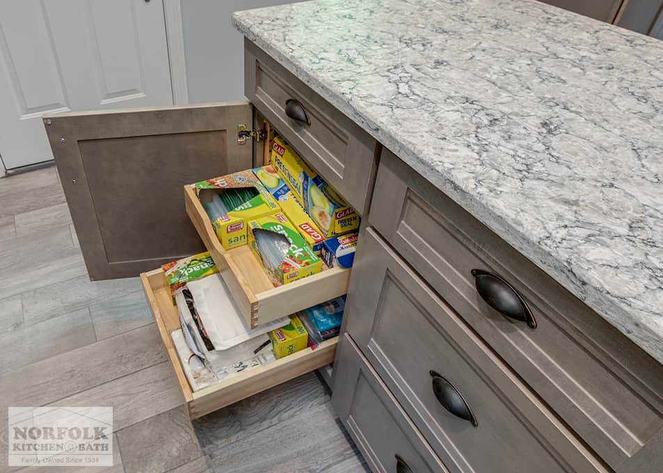 close up of base cabinet pull out drawers with various plastic bag containers inside