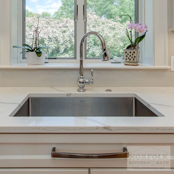 stainless undermount sink with faucet in a white kitchen