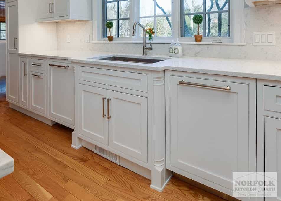 white base cabinets with decorative molding around the sink